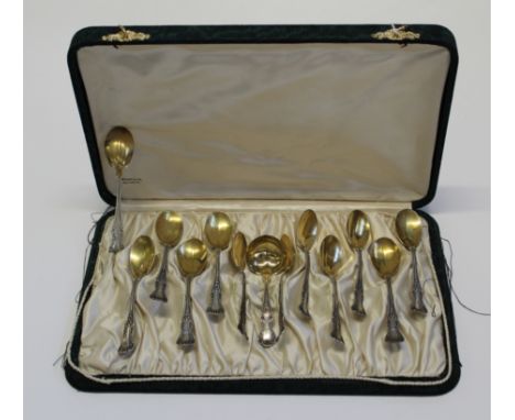 A green silk case set of twelve American Art Nouveau '' sterling'' stamped dessert spoons with a small ladle. All engraved wi