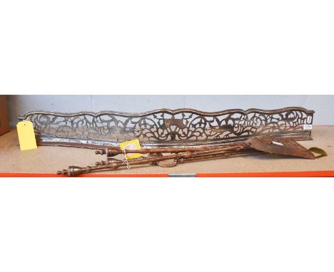 A George III Pierced Steel Fender, decorated with dragons, together with a set of three fire tools, fender 120cm
