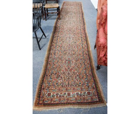Sarab Runner, the camel ground with a column of ivory hexagonal medallions enclosed by multiple borders, 485cm by 99cm