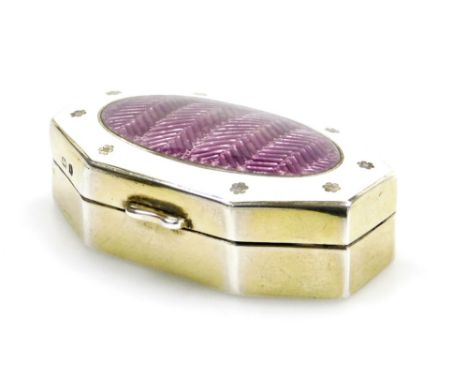 A George V octagonal pill box, the lid with a mauve coloured central enamelled panel surrounded by a white enamel border deco