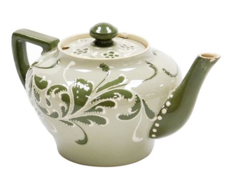 A Macintyre and Co Esso Faience bachelor's teapot and cover, decorated with scrolls and flowers in green and white against a 