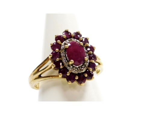 A 9ct gold ruby and diamond set dress ring, the oval ring head with central ruby, and further halo of tiny diamond and outer 