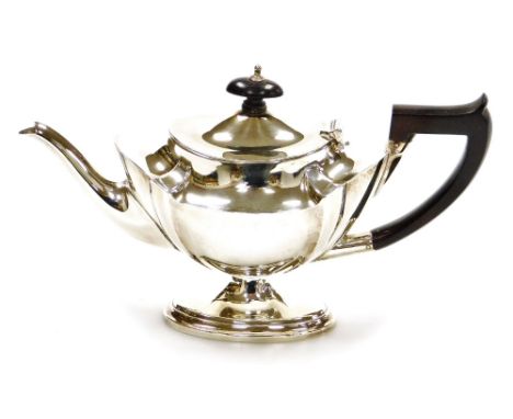 A George V silver bachelor teapot, of part fluted form, on an oval stepped base, Birmingham 1911, 14cm high, 10¼oz gross. 