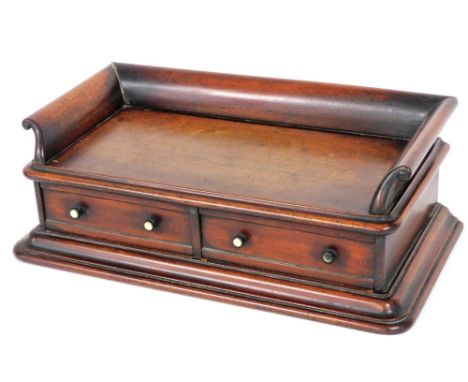 A 19thC mahogany desk stand, with a three quarter raised gallery above two drawers, each with ebonised and ivory handles, on 