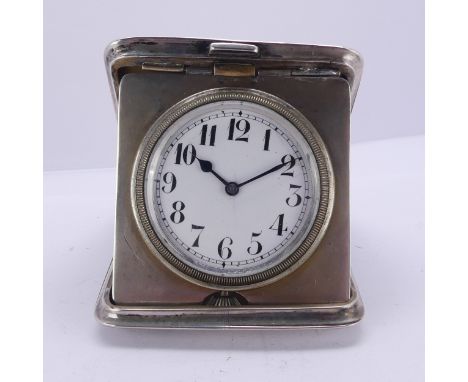 A George V silver folding Travel Clock, by Henry Matthews, hallmarked Birmingham 1916, the unsigned white enamel dial with Ar
