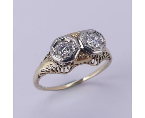 A two stone diamond Ring, each circular stone approx. 0.2 ct, mounted in unmarked yellow and white gold, tested as 14ct, Size