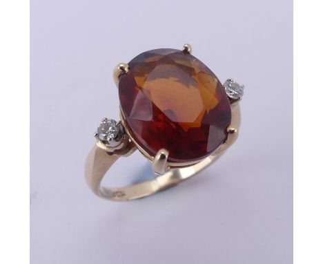 A fire opal and diamond Ring, the central oval facetted stone approx. 12mm long, four claw set in 14k yellow gold with a smal