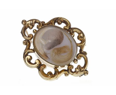 LATE VICTORIAN MOURNING BROOCH
with a central oval crystal covered hairwork panel, 48mm long, unmarked