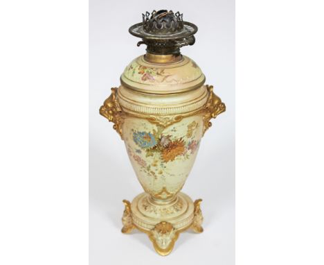 A Royal Worcester blush ivory oil lamp base of baluster form with gilt grotesque mask handles, floral splays, circular platfo