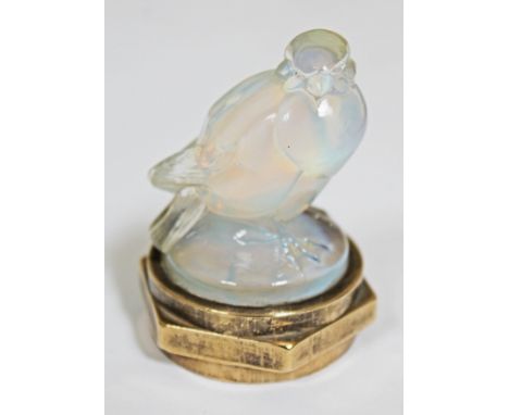 A Lalique opalescent glass bird inscribed 'R Lalique Homes No284', mounted on brass nut, height 6.5cm.