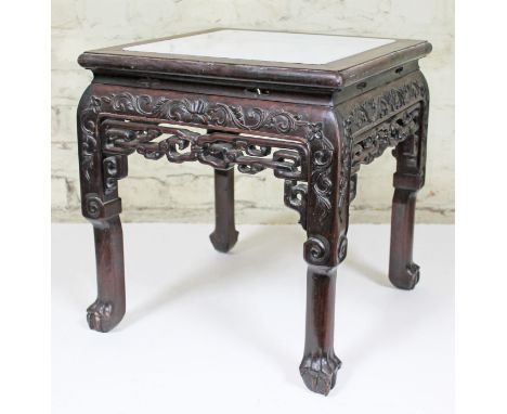 A Chinese hardwood plant stand, 19th Century, having marble top, carved scroll and foliate detail, pierced frieze, claw and b