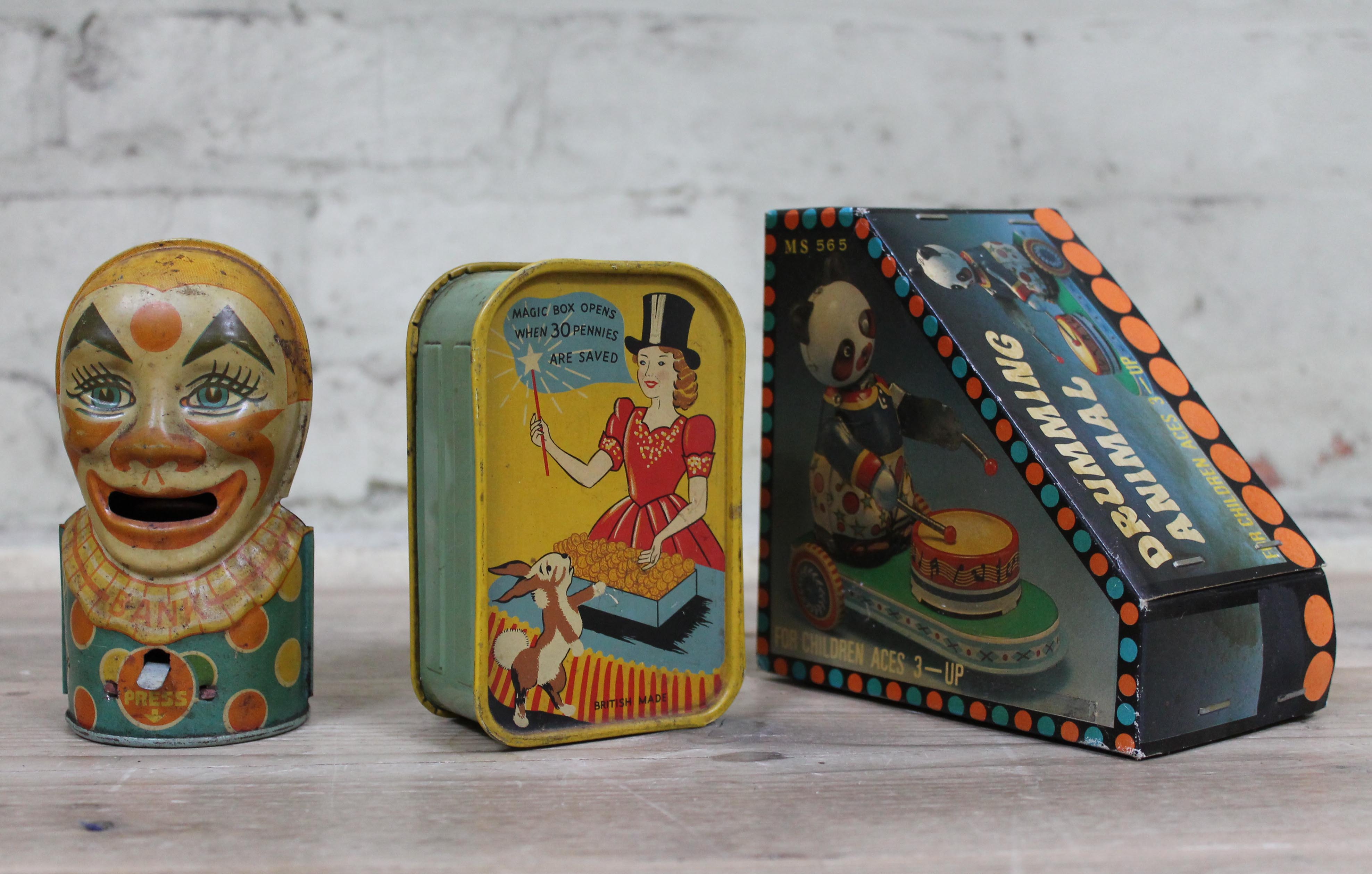 A J Chein clown money box, a Codeg Magic money box and a tinplate toy.