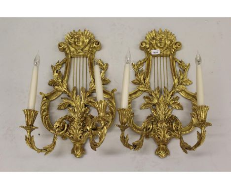 Pair of 19th Century carved and gilded lyre form twin light wall sconces, with mask head and acanthus embellishments, 21ins h