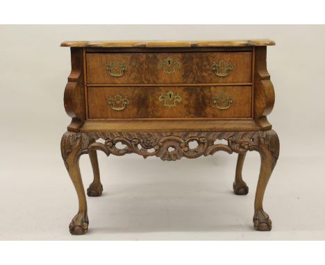 Continental burr walnut commode chest on stand, the top with herringbone inlay and shaped edge above two long drawers with br