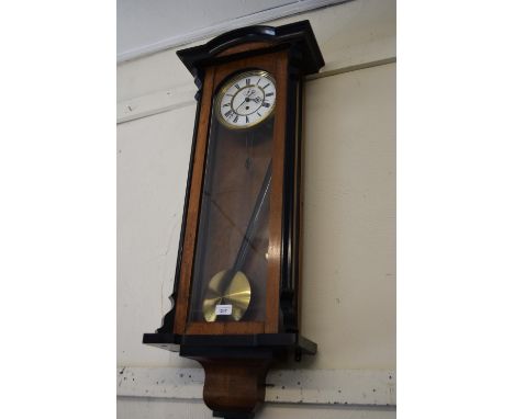 Vienna walnut and ebonised wall clock, the white enamel dial with Roman numerals and subsidiary seconds, with a single train 