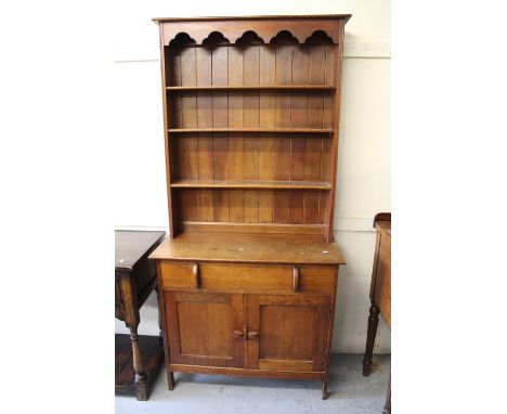 Small Arts and Crafts oak dresser, the boarded shelf back above a single drawer and a pair of panel doors, 36ins x 16.5ins x 