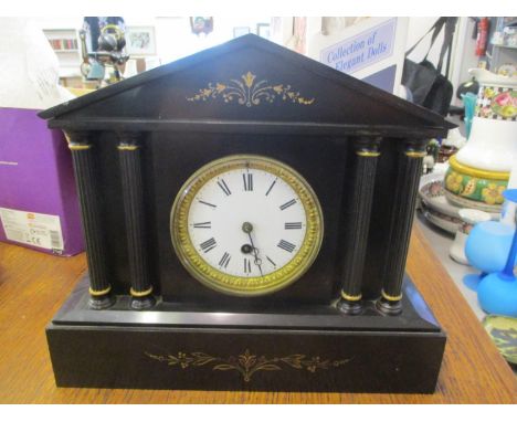 A Victorian black slate mantel clock of architectural design having a white enamel dial with Roman numerals 