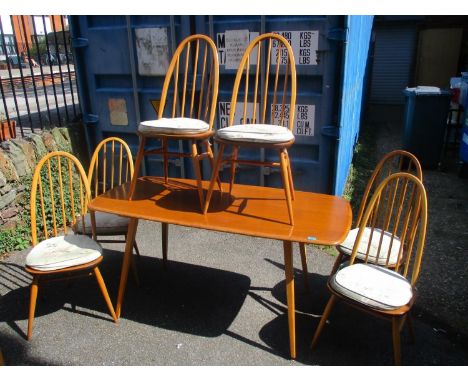 A light Ercol dining table 29"h x 58 1/2"w, together with six spindle back dining chairs 