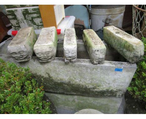 A pair of wreathed garden concrete trough planters on five gargoyle mask block feet 
