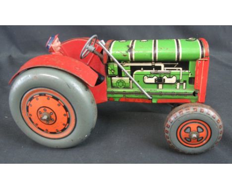 Vintage tinplate painted model of a tractor with red chassis and grill, grey wheels and orange hubs.  Printed marks: Made in 