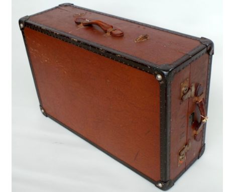 A vintage wooden and clad clothes hanging trunk labelled 'Watajoy', handles at top and side. Opens up with straps and hanging