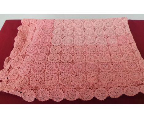 A vintage hand crocheted bedspread in three subtle shades of dusty pink, the palest section being in the middle. This piece w