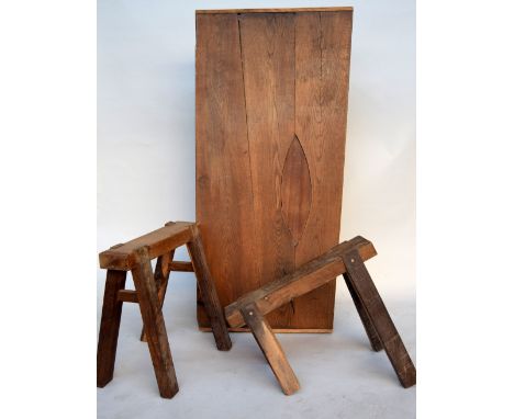 A robust hardwood trestle table of primitive design attributed to the Bloomsbury Group, the plank top on two trestle base (on