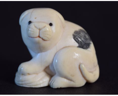 A Japanese netsuke in the form of a crouching puppy, Meiji period