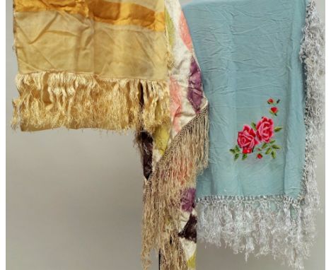 Three vintage shawls. A circa 1920s triangular silk shawl with  fringing. A pale blue silk shawl with embroidered roses in th