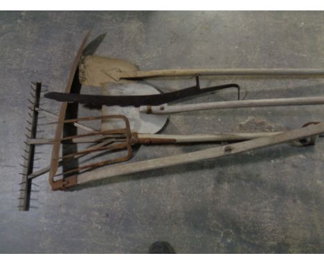 A bundle of farming tools including hay fork, scythe, wooden paddle etc 