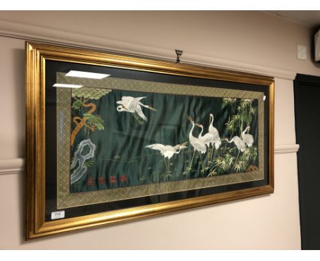 A Japanese silk panel depicting storks, 95cm by 43cm