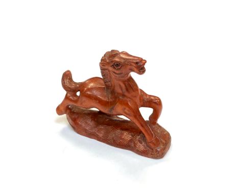 A Japanese carved fruitwood netsuke - Prancing pony. 