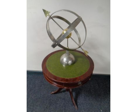 An armillary sphere together with a circular pedestal drum table with green leather inset panel 