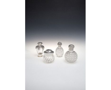 A COLLECTION OF FOUR CUT AND MOULDED GLASS DRESSING TABLE CONTAINERS WITH SILVER MOUNTS, comprising: a fluted baluster scent 