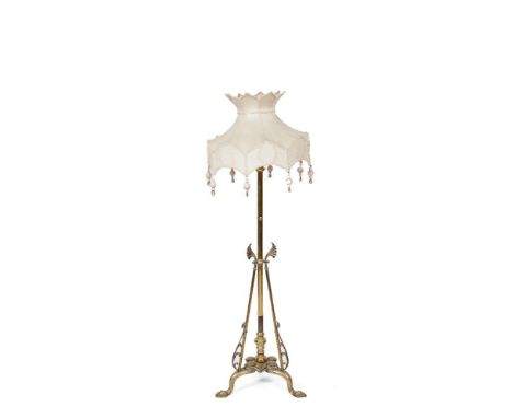 AN ART NOUVEAU BRASS STANDARD LAMP, c.1900, with tubular shaft and triform support, stylized lotus base with scroll and pad f