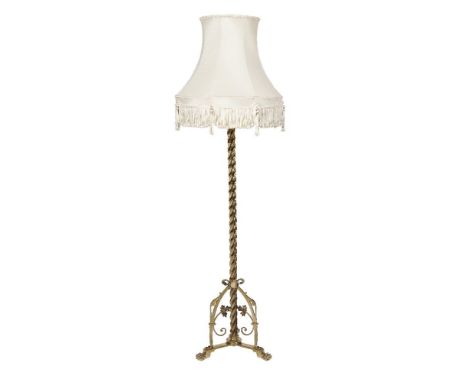 A CAST BRASS STANDARD LAMP, the plain spiral turned column raised on a tripod base, terminating on paw feet. 140cm high with 