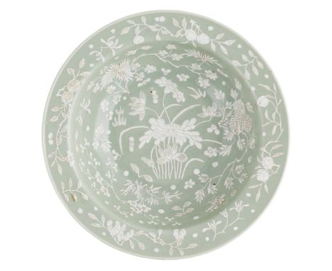 CELADON GLAZED DEEP BASIN WITH SLIP DECORATIONQING DYNASTY, 19TH CENTURY with a canted rim and wide well, painted in white sl