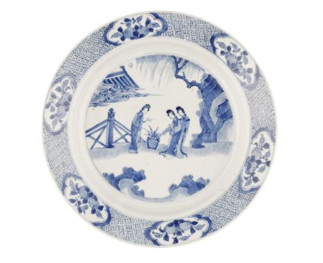 BLUE AND WHITE DISHCHENGHUA MARK BUT KANGXI PERIOD painted with three ladies attending a jardinière of flowers in a fenced ga