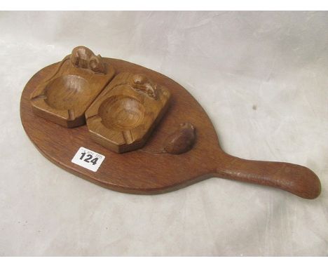 Two light oak carved Thomas Mouseman ash trays, together with an oval formed cheese board