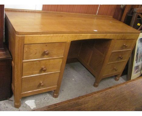A 1930s light oak Thomas Mouseman desk having six drawers with turned knop handles on turned feet