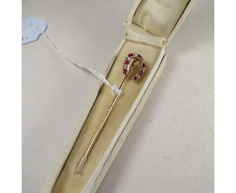 A yellow gold ruby and diamond set horseshoe stick pin