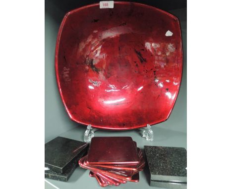 A large ceramic bowl with red glaze and similar tablemats etc