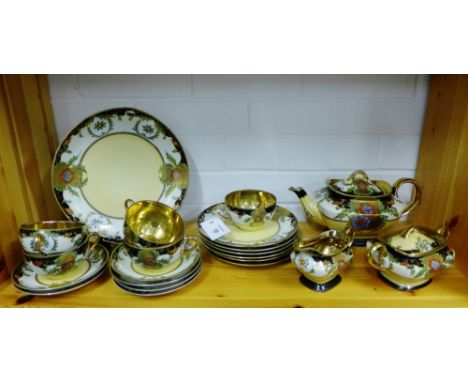 A Japanese Noritake style tea set painted with flowers and foliage with gilt highlights and gilded interiors, comprising teap