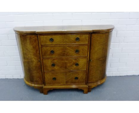 A mahogany veneered side cabinet with four graduating drawers flanked by bow fronted cupboard doors on bracket supports, 108 