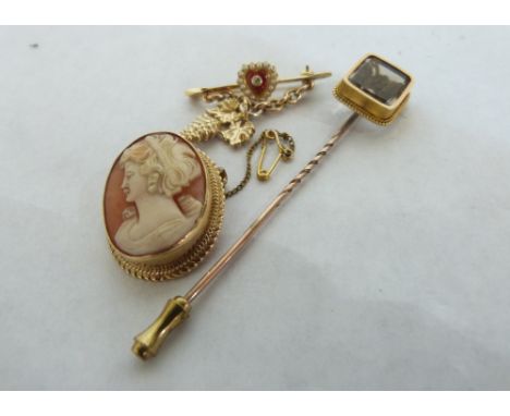 A 9ct shell cameo brooch; a split pearl and enamel brooch and a quartz set stick pin