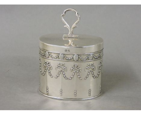 An oval silver tea caddy, Henry Matthews, Birmingham 1910, embossed with floral swags and ribbons, 6.5cm high