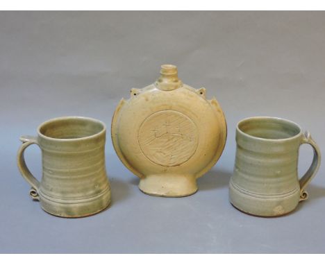 Leach pottery and Lowerdown pottery, a moon flask inscribed with the Crucifixion Hill, 18cm high, and two mugs, 11cm high