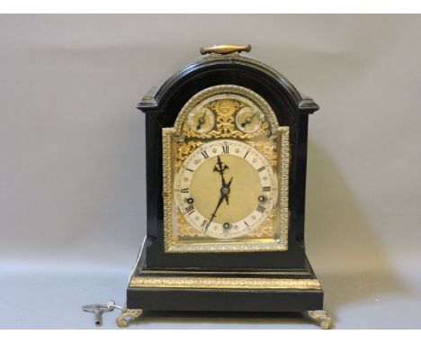 An ebonised and gilt mantel clock, the arched silvered dial with CHIME/SILENT and SLOW/FAST dials, chiming on five gongs, wit