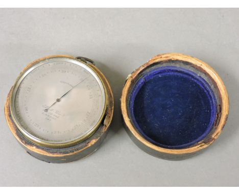 An Elliott Brothers pocket barometer, in a leather case, worn, cover loose, 7.5cm diameter