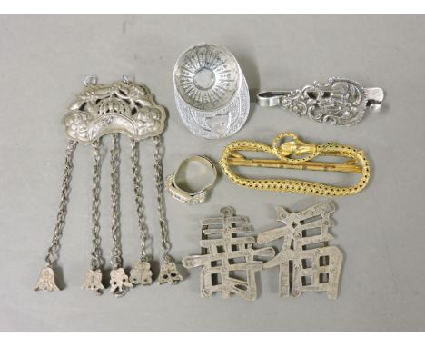 A silver jockey cap caddy spoon, a ring, a buckle formed of the characters of Fu and Shou, a pendant hung with bells, a gilt 